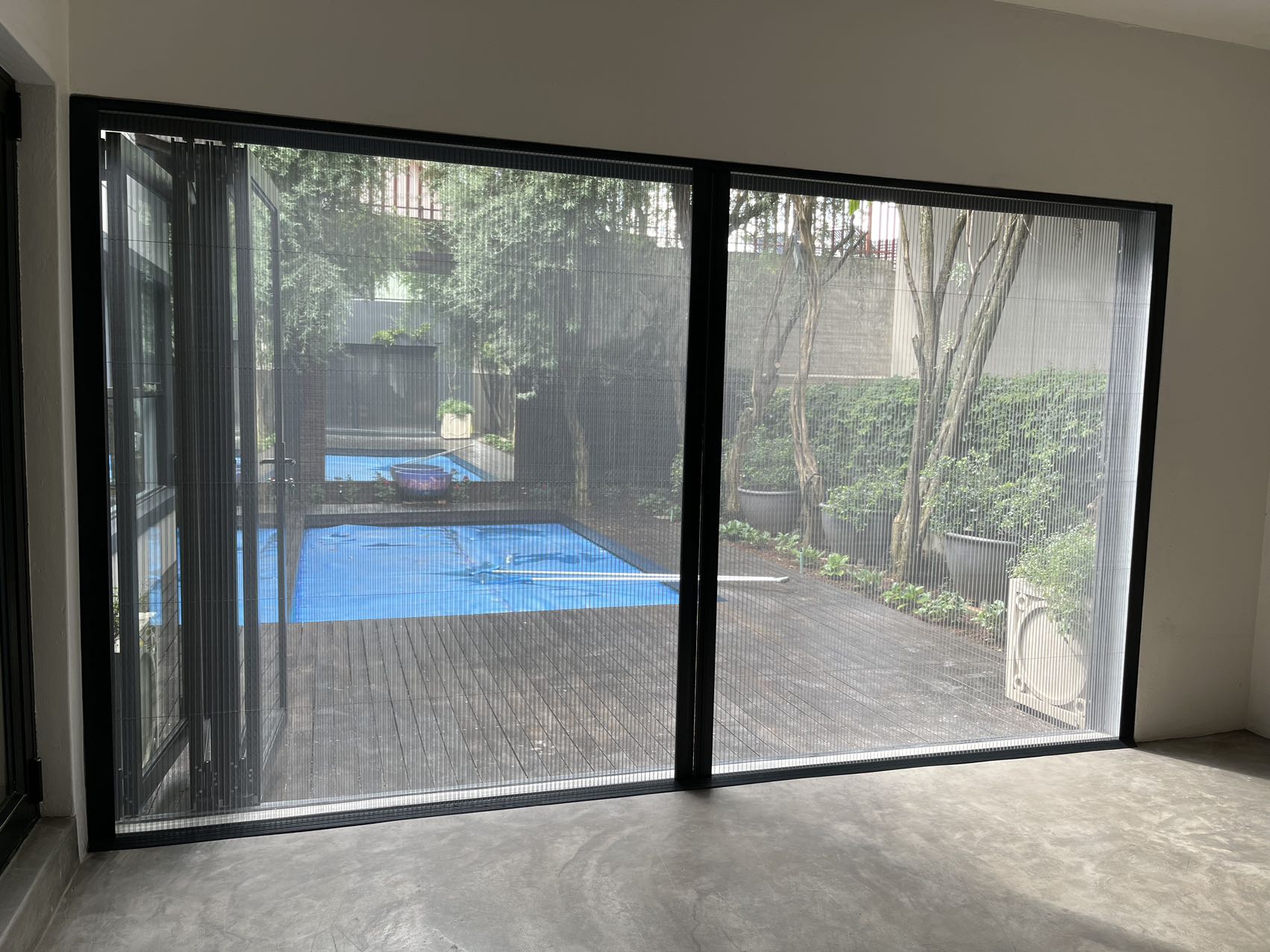 Custom pleated screen fitted to a bright residential window